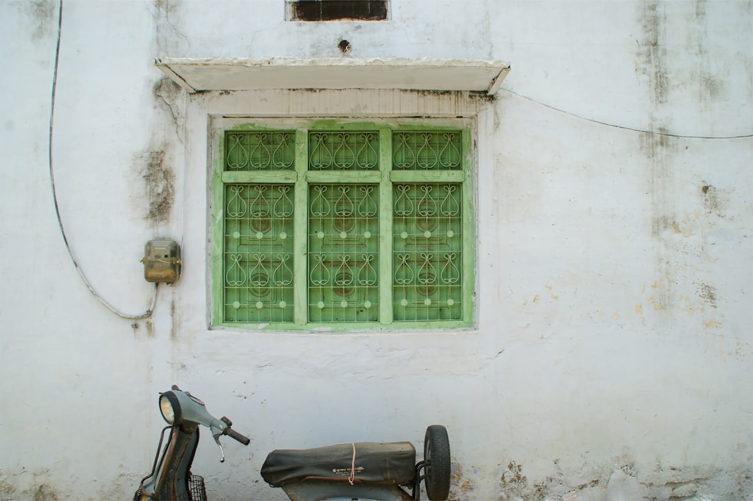 black motorcycle parked beside white concrete building